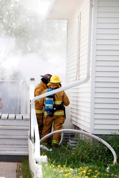 Firefighters respond to a call from a nearby resident about smoke coming from the basement of a Barrhead home on Monday, June 1.