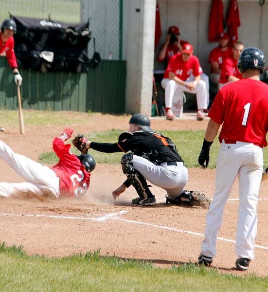 Orioles &#8216; catcher Dean Rau tags Camrose Axemen player Riley Guntrip as he slides into home plate.
