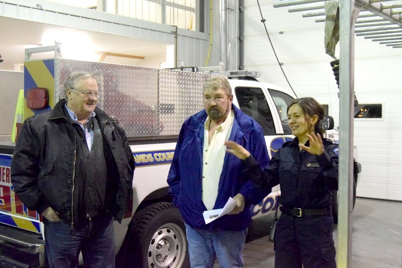 Firefighter Gerry Schulte (r), talks to Woodlands County councillors Dale McQueen (m) and Dan Pritchard about the department &#8216;s RDC inflatable.