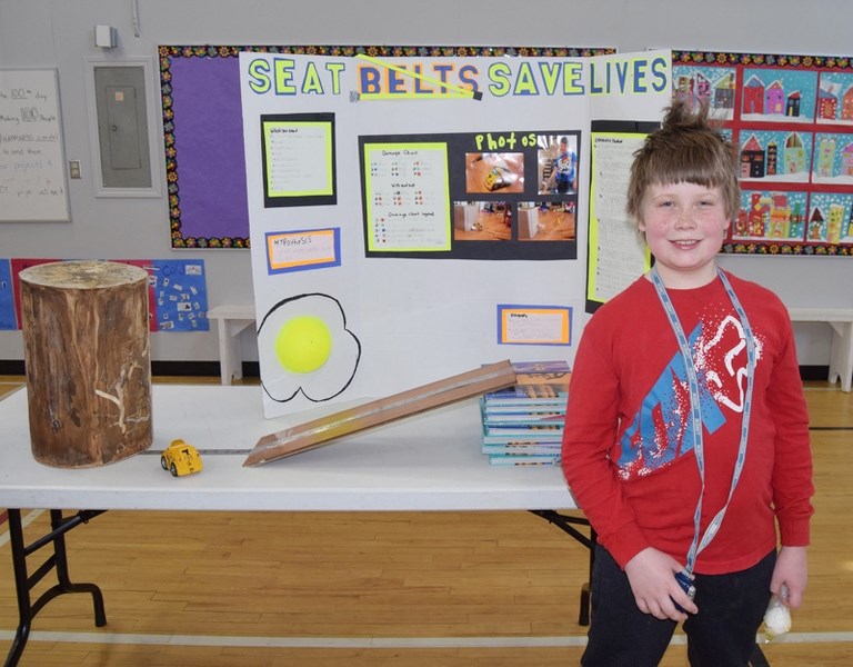 Nicholas, Grade 5, with his science project on the safety of seatbelts.