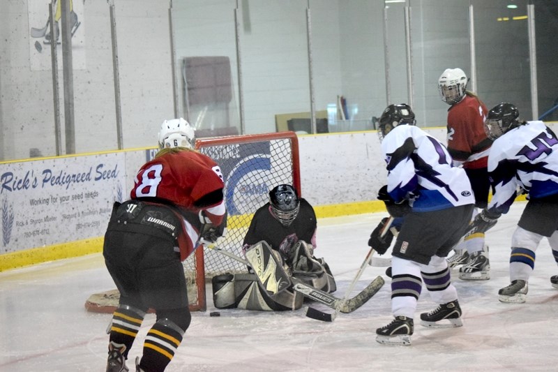 Fort Assiniboine Jagged Edge goaltender Jordan Adams looks for the loose puck after making a save during a game against the Edmonton Chiefs.