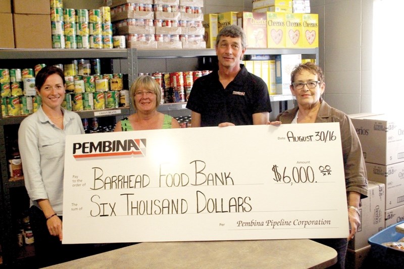 FCSS worker Robin Kapler (l), and food bank volunteers Peggy Carty and Jeannine Kowalski (r ) accept a $6,000 donation from Pembina Pipeline Corporation representative John