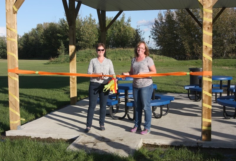 Parents Tracy DeZaeyer (l) and Krista Schole, who spearheaded the Dunstable outdoor classroom project, officially cut the ribbon on one of the outdoor structures last