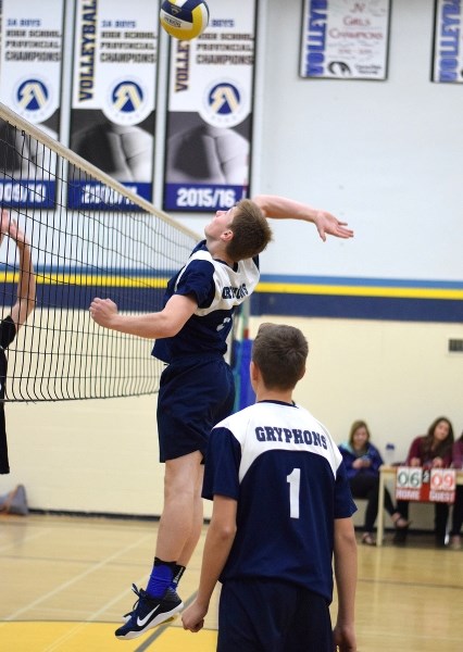 Spencier Meunier leaps up in the air to spike the ball against his Westlock opponents.
