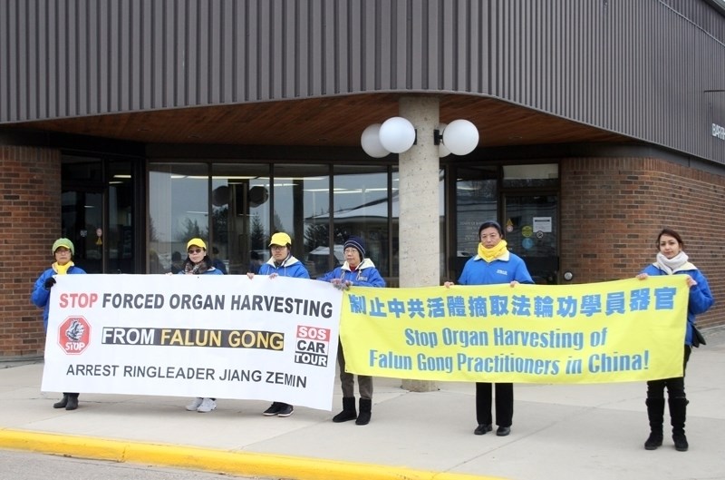 Members of the Human Rights Car Tour advocating an end to forced organ harvesting and the persecution of Falun Gong practitioners stage an impromptu press conference infront