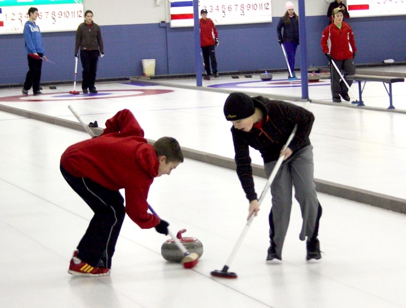 Two boys sweep the stone in a game as part of last year &#8216;s premier Junior Bonspiel. This year &#8216;s will be held Dec. 17 and 18 in Barrhead.