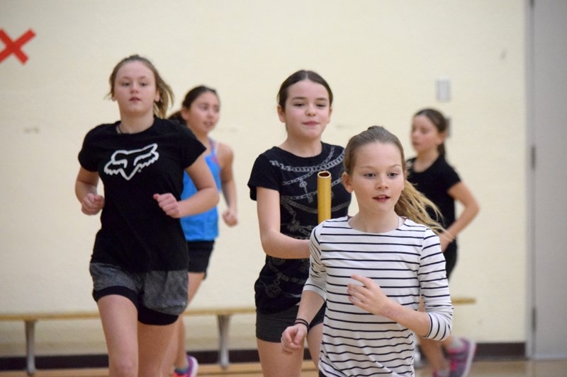 Rylyn Hayes leads a group of runners, Karmaq Floden (behind left) Courteney Harrison (behind right) during a warm up drill.