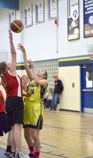Portia Kuharic of the BCHS Jaguars takes a shot over the outstretched hands of Westlock defender in the second game of the tournament. The Jags lost the game 33 to 28.
