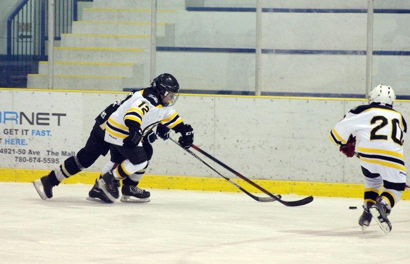Tayten Bain keeps pace with an Onoway Eagles player, while teammate Trysten Hallock closes in.