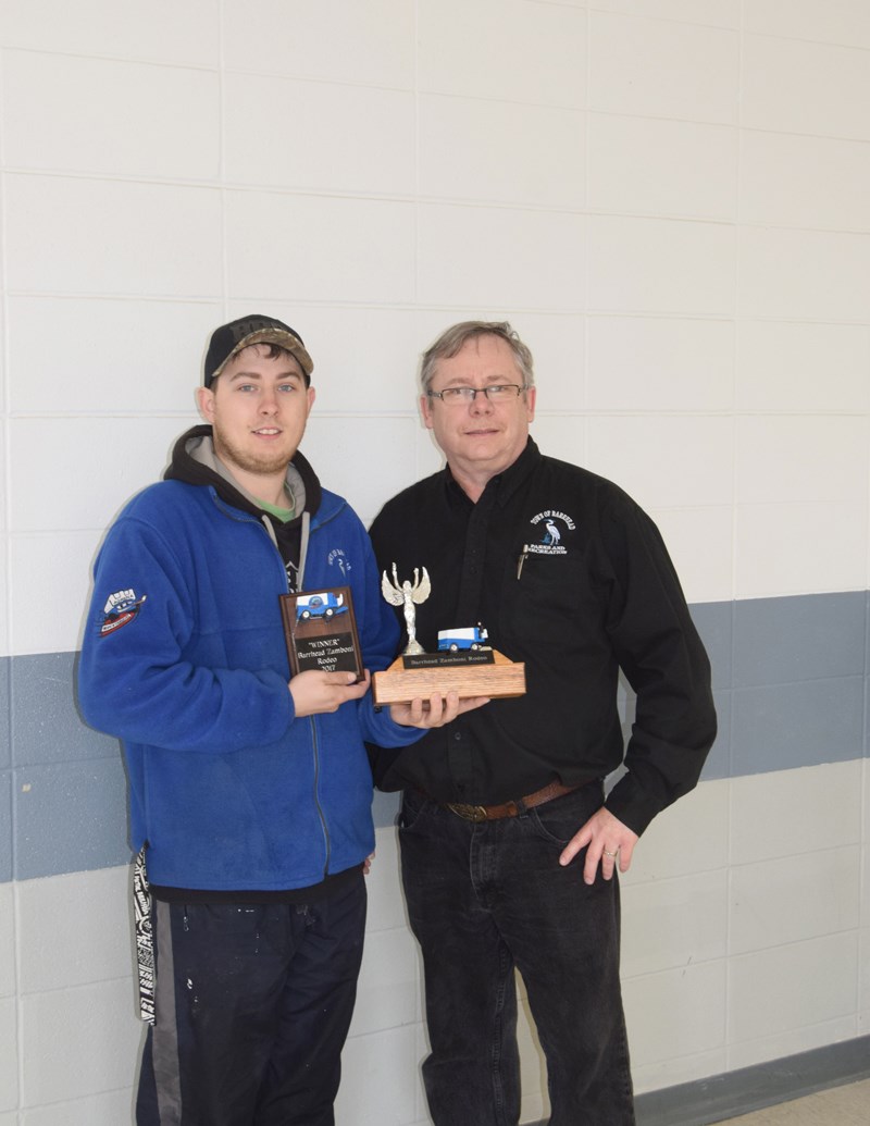 Parks and recreation director Shallon Touet (r) presents Nathan Croft with the first ever Barrhead Zamboni Rodeo plaque and trophy on Monday, April 10.