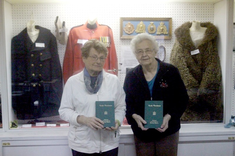 Barrhead Historical Society president Anna Churchill and society treasurer Elsie Measures pose for a photograph with two copies of the book Northwest Trails. Originally