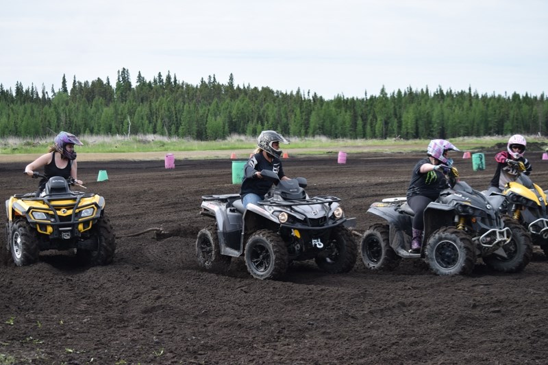 The Flirting with Disaster team rounds the first corner of the obstacle course pulling a metal sled or chariot. The object of the race is that each person of the four person