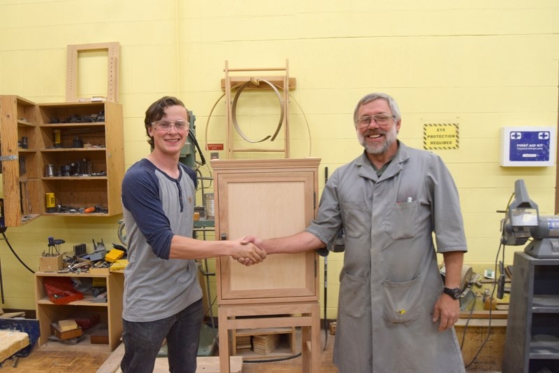 BCHS industrial arts teacher Barry Wilkins (r) congratulates student Dawson Fisher once again for winning silver at the Skills Canada national competition. The cabinet Fisher 
