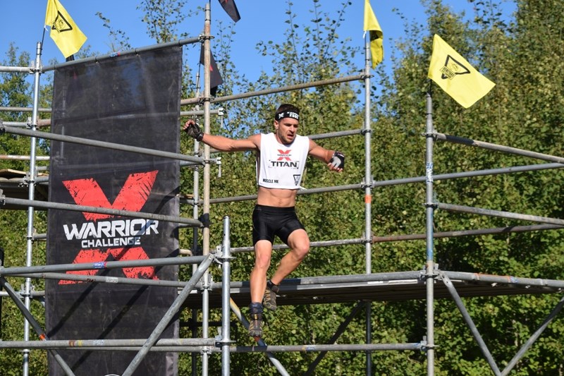 Neerlandia &#8216;s Murray Tuininga, in the titan class, jumps off the scaffolding after successfully climbing the warped wall.