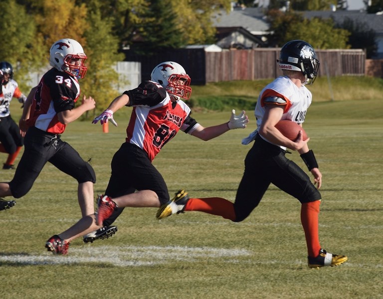 Thunderbirds Stephen Tkachyk (centre) and Waylon MacDonald chase down a St. Paul Lion.