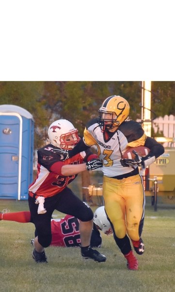 Thunderbird Robert Bokenfohr grabs at Wainwright Commando Dayton Gibb in the first quarter.
