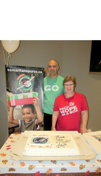 Operation Christmas Child co-organizers, Herb and Derra Mantey, pose with a cake celebrating Barrhead Alliance Church &#8216;s 10 anniversary in heading the project.