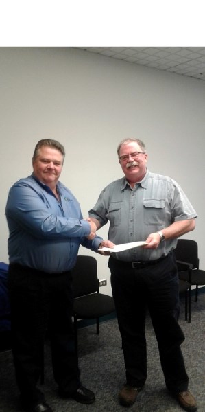 County of Barrhead reeve Doug Drozd (l) shakes hands with Town of Barrhead mayor Dave McKenzie (r) after the county accepted the Municipal Affairs-approved recreational