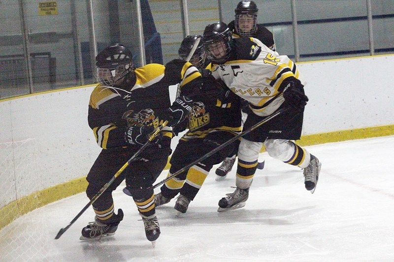 Barrhead Steelers player Owen Weeks corrals a pair of Athabasca Hawks players behind the Hawks &#8216; net, during a regular season matchup Nov. 24 that ended 4-1 for