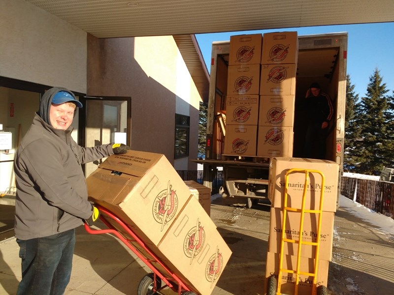 Kevin Kuschminder brings out a dolly full of Operation Christmas Child shoeboxes to the truck during a Nov. 19 packing party at the Barrhead Alliance Church.