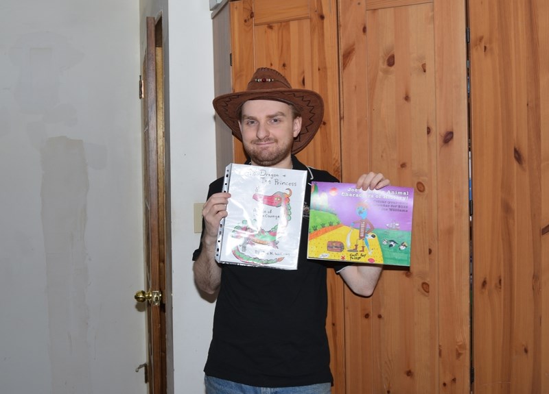 Joe Williams holds up one of the prospective pictures he is considering to be the front cover of his book as well as his 2018 calendar.