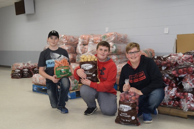 From left: Riley Harrison, Peyton O &#8216;Malley and Keenan Stranaghan of the Barrhead Bantam Pirates were on hand to help load people &#8216;s carrot and potato orders at