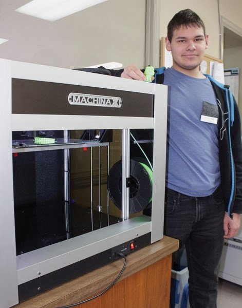 Westlock Library volunteer Shadrach Salinas poses with the library’s 3D printer Jan. 17 as it prints out a model of a caterpillar. The printer was offline for the last two