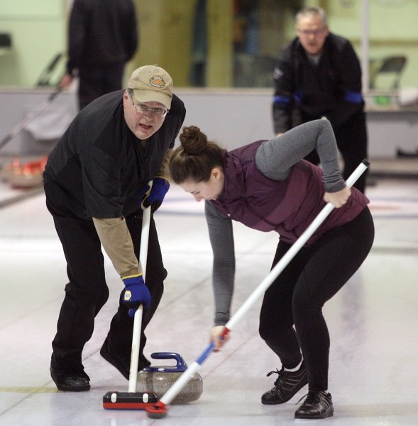 Vernon Glebe and Ann-Marie Carnegie of the Terry Sheehan rink hurry hard in the