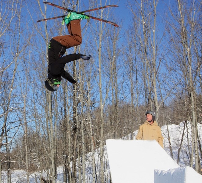Zachary Strydhorst catches air off a jump at the Pine Valley Resort Feb. 3 while coach Mike Flewwelling watches in the background. Strydhorst was practicing for the upcoming