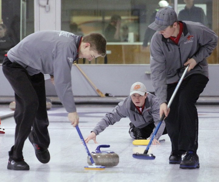 R.F. Staples Colton Dubovsky looks on as teammates Mack Hay and Ryley Letts sweep during the Alberta School Ath-letic Association North Central Zone Championships held Feb.