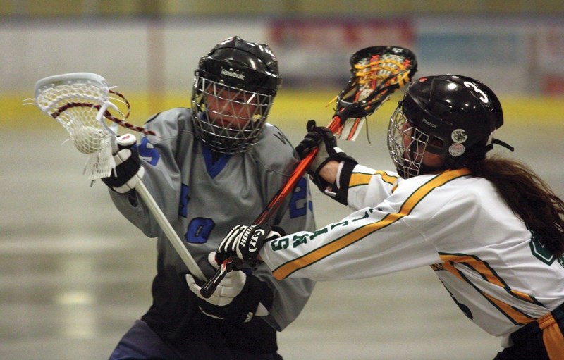 Pee wee Rock&#8217;s Katie Sawchuk (left) fights hard to get around a Sherwood Park Titans player during the club&#8217;s 1-1 April 28 tie at the Rotary Spirit Centre. The