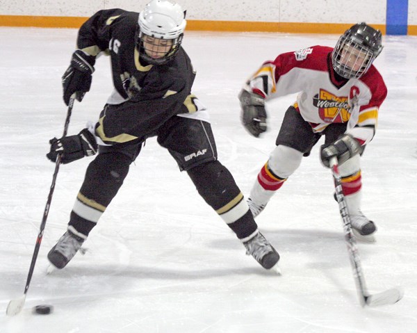 Adam Hardinge of the Westlock Pee Wee Krusaders scuffles for the puck with the Devon Drillers&#8217; Adam Wearden during the Krusaders&#8217; 5-4 victory over Devon last