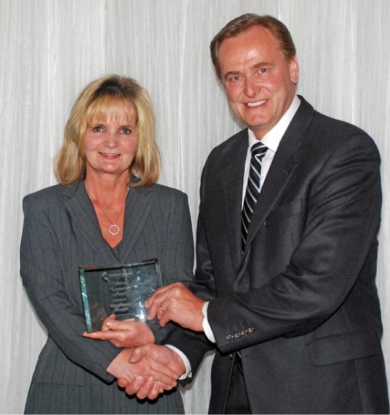 Donna Jackson of Sanderman Home Hardware of Barrhead, accepts the Business of the Year Award on behalf of Bruce and Janice Steinbring from Canada&#8217;s Minister of State