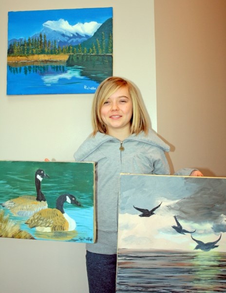 Rachelle Zadunayski shows off some of the artwork she will be auctioning off to help kids who have undergone brain surgery attend Camp He Ho Ha.