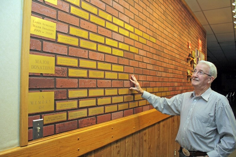 Mel Primrose shows off the plaques commemorating former Legion members and the organization&#8217;s charitable track record in the hall&#8217;s main hallway.