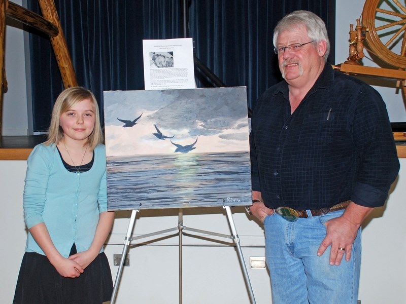 Rachelle Zadunayski with her painting sold at the Youth for Christ banquet in Westlock Feb. 19. At right is Alan O&#8217;Brien, who purchased it for $1,400.