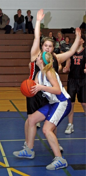 St. Mary Shark Angela Doell pushes past a Mayerthorpe defender to take a shot during Saturday evening&#8217;s consolation final. The Mayerthorpe Tigers won the game 40-27.