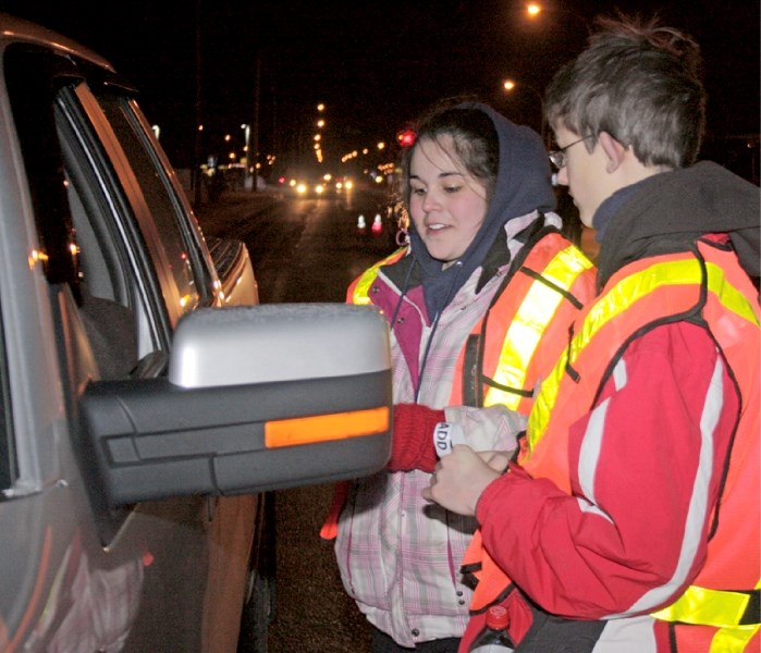 Nadine Duperron and Josh Block, members of St. Mary&#8217;s Students Against Dangerous Decisions, speak to a motorist about the dangers of drunk driving at an Alberta