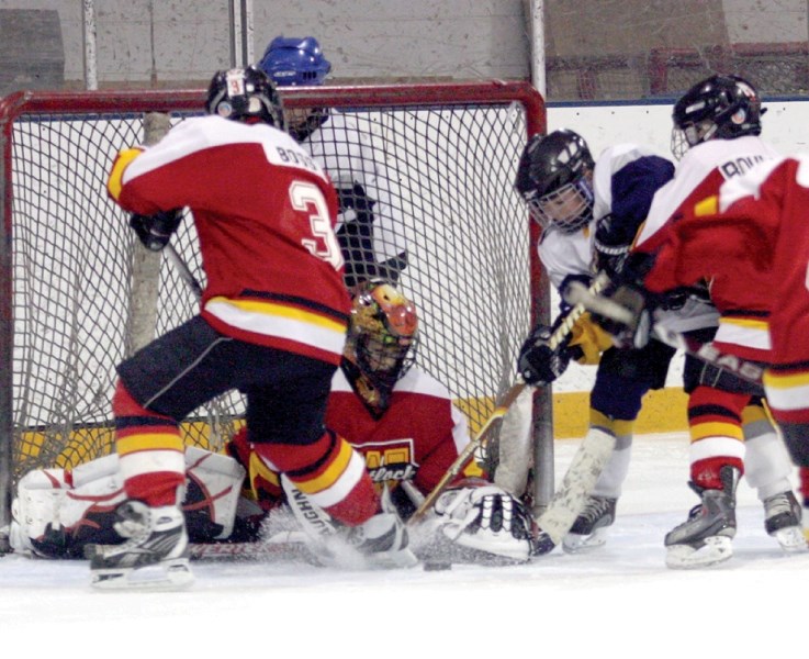 Goalie Jayden Vandelagemaat searches for the puck while teammates Jared Boss (#3) and Blair Boulerice fight off a CNN Spurs attacker March 19 at the Atom &#8216;B&#8217;