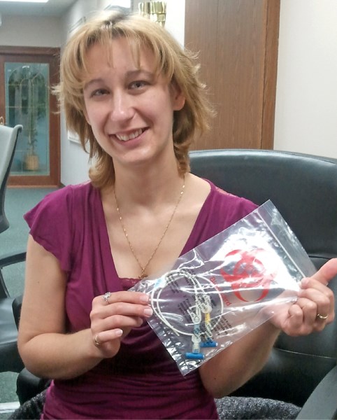 Lori Rakowski holds up a bag containing a PICC catheter, which she has kept as a reminder of the time she spent in hospital battling cancer. The catheter went in her arm and