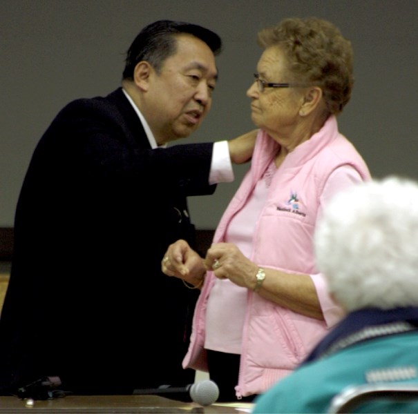Dr. Steven Aung demonstrates qi gong on Olga Wingrove during the &#8220;Art of Aging &#8221; conference in Westlock last Friday.