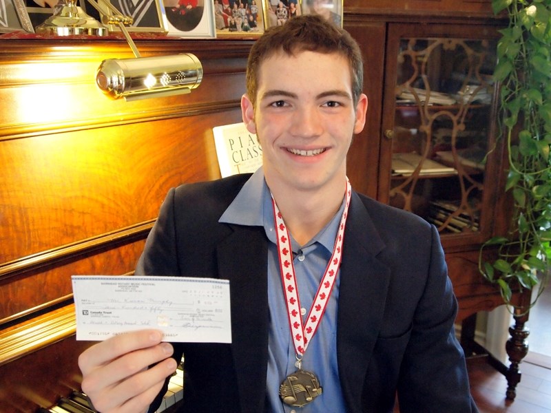 Kieran Murphy shows off the cheque and medal he won at this year&#8217;s Barrhead Rotary Music Festival in March.