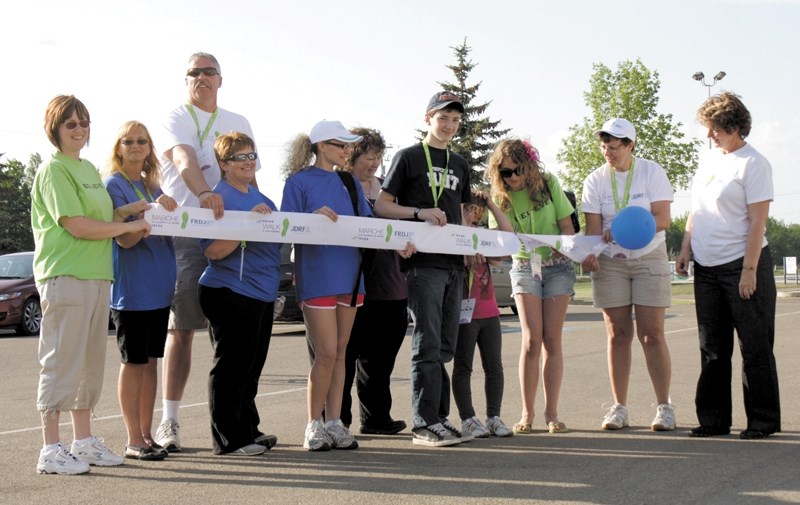 Graham Schole (centre) and Ryley Patriquin (third from right) help to cut the ribbon opening the ninth Walk to Cure Diabetes June 2 at the Westlock Rec Centre. The