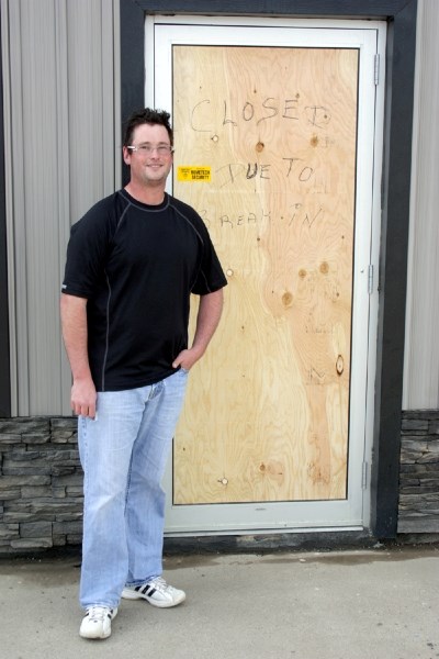 Ryan Provencal stands by the boarded-up entrance to his store, NAPA Auto Parts, on Tuesday afternoon. Thieves made off with $5,000 worth of merchandise in a recent break-in,