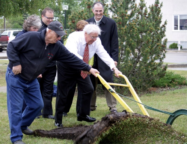 Barrhead-Morinville-Westlock MLA Ken Kowalski gets a helping hand from Rod MacFarlane turning the first furrow of sod for the Pembina Lodge expansion June 15. The expansion