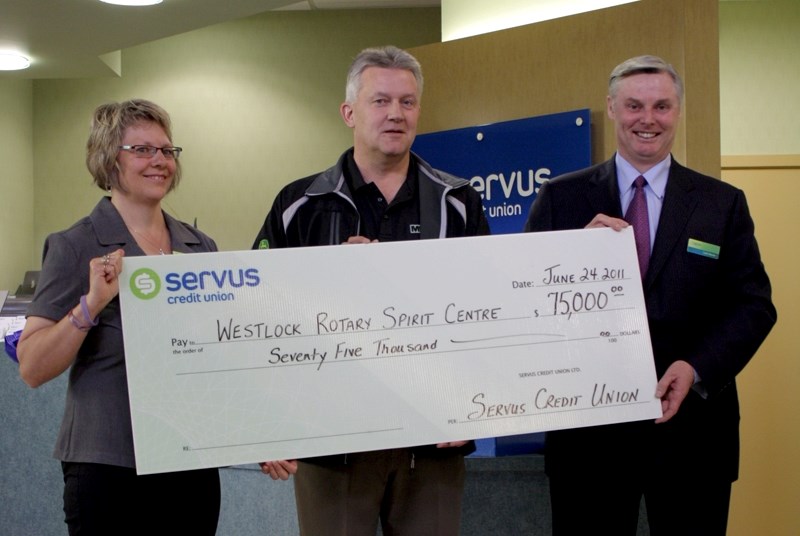 Servus branch manager Helene Zadunayski and CEO Garth Warner present Spirit of Westlock Foundation president Wayne Peyre (centre) with a $75,000 donation.