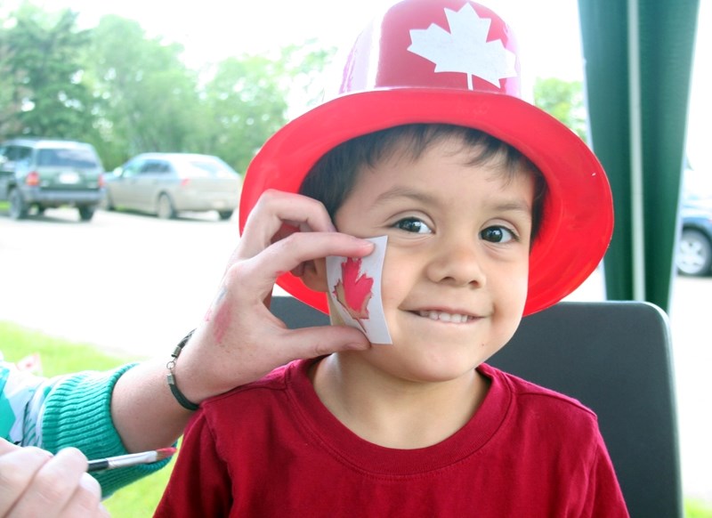 Riley Chattargoon, 4, displays some Canadian pride as he gets a bright red maple leaf painted on his face at the family barbecue outside the Westlock Recreation Centre on