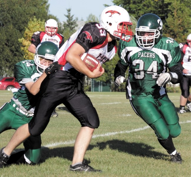 Chase Boyson struggles to break free of a tackle from Athabasca&#8217;s Andrew Morey while Jeremy Major moves to help him out. A strong showing in the first half of the