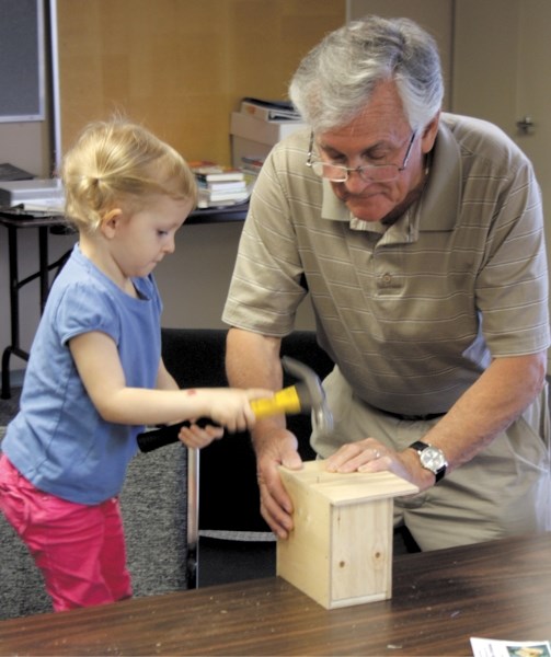 Katie Campbell, 3, helps her grandfather Jim Campbell put together a birdhouse at the &#8220;Dad and Me &#8221; birdhouse making day at the Westlock FCSS office Saturday.