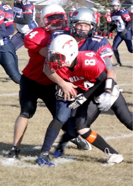 T-Bird Stefan Toivonen (84) gets a little help from defensive end Adam McMillan (94) as he&#8217;s brought down by a Bonnyville Voyageur. The T-Birds finished their playoff